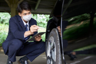 査定スタッフが車の外装を点検し、コンディションを丁寧にチェックしている様子